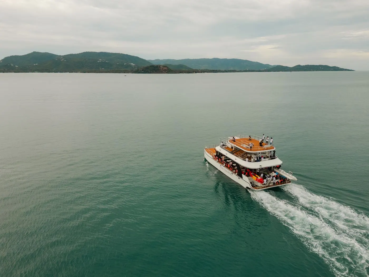 Der Katamaran von Samui Journey fährt übers Meer und zieht eine weiße Spur