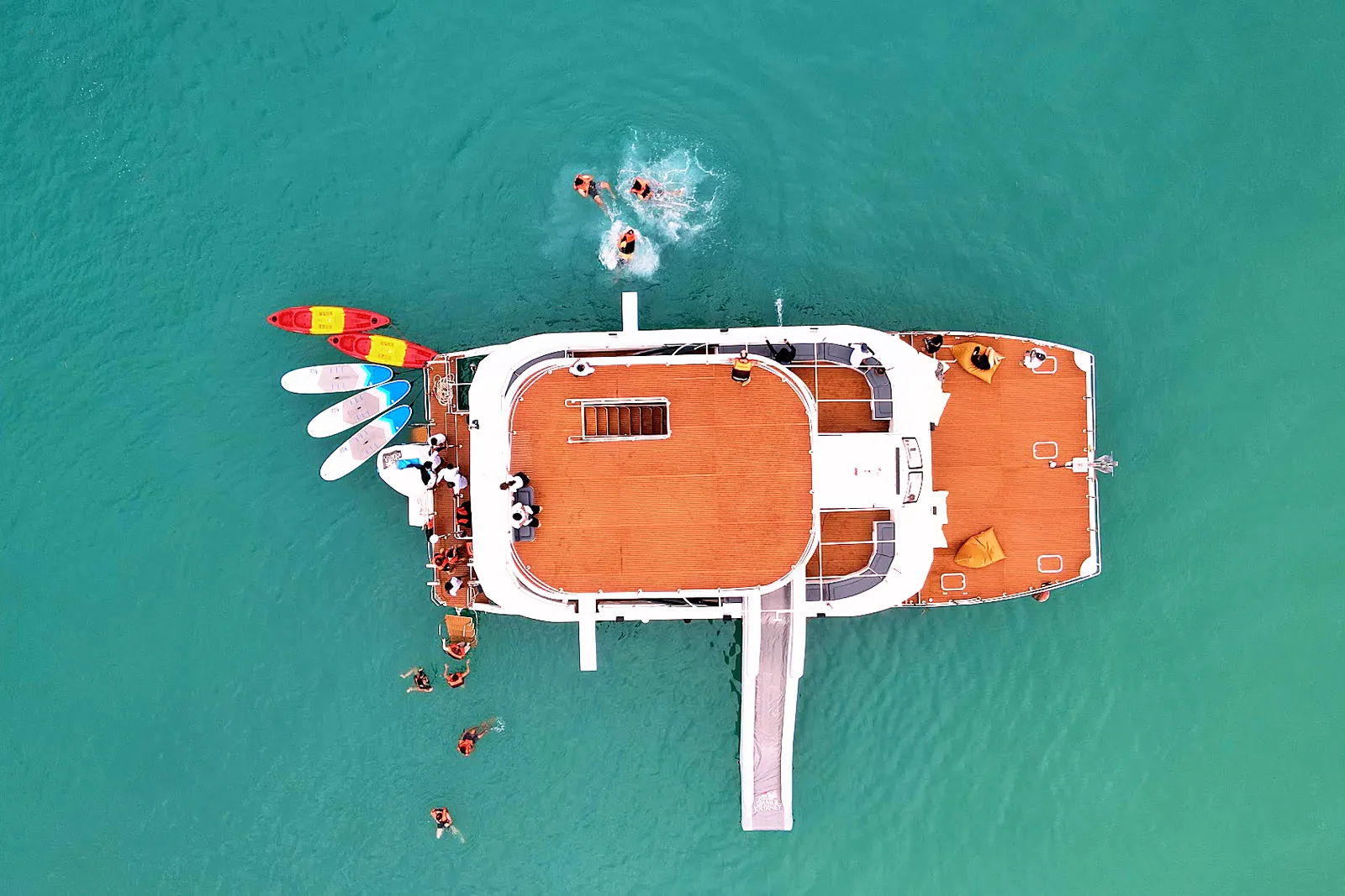 Le catamaran Samui Journey vu du dessus avec ses kayaks, ses paddles et son toboggan, des passagers nageant à côté