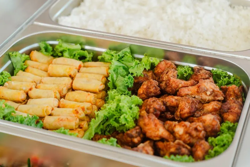 Spring rolls, fried chicken and rice for lunch on board, part of the Koh Samui catamaran price