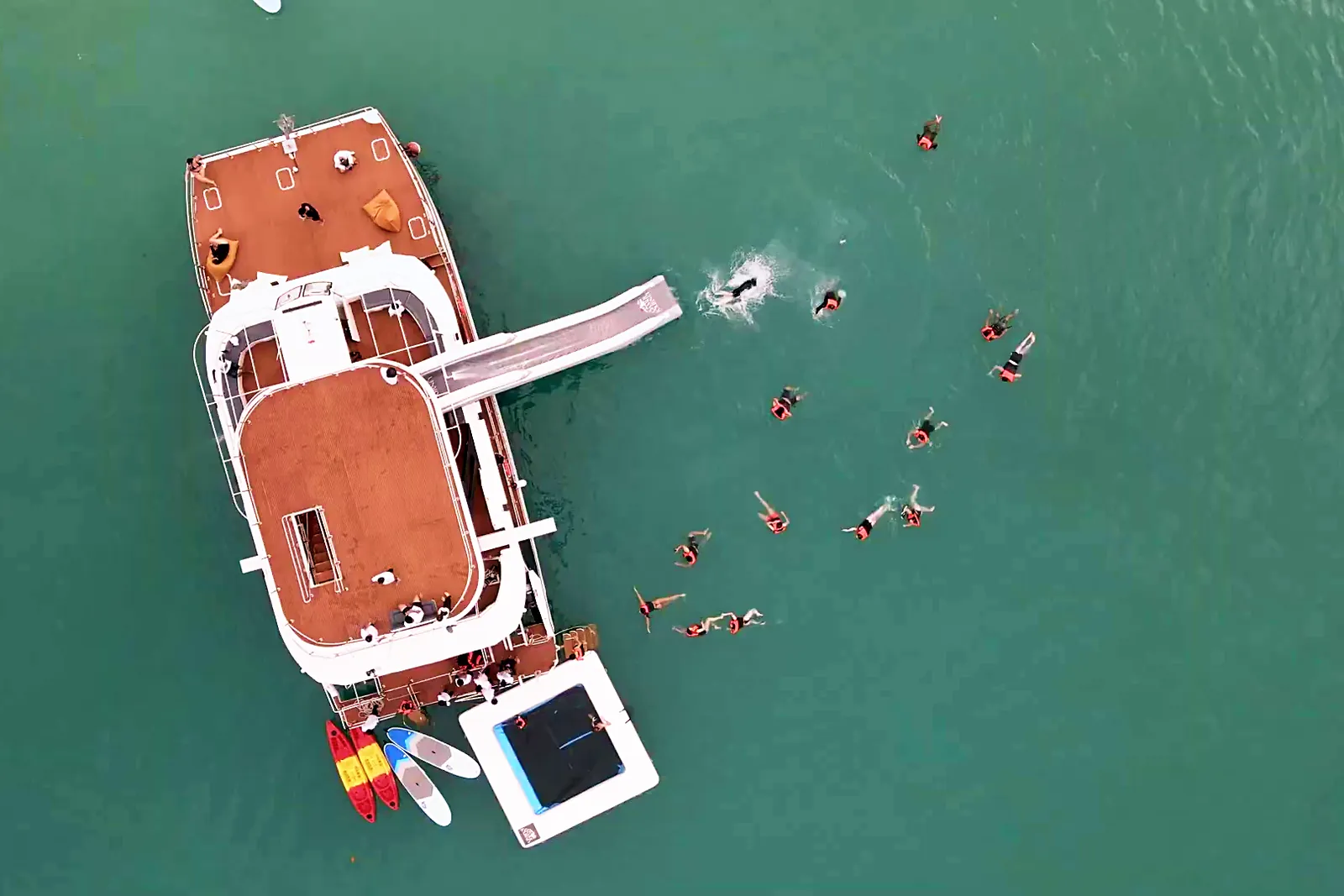 Aerial view of the catamaran water slide with guests swimming beside it