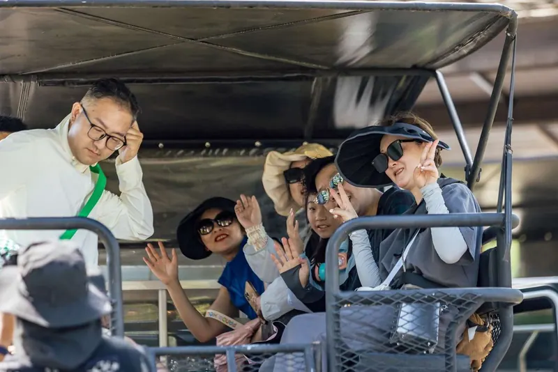 Guests smiling and waving from the back of the 4x4 safari truck