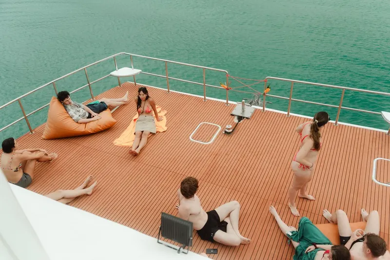 Guests on bean bags on the catamaran sun deck between stops